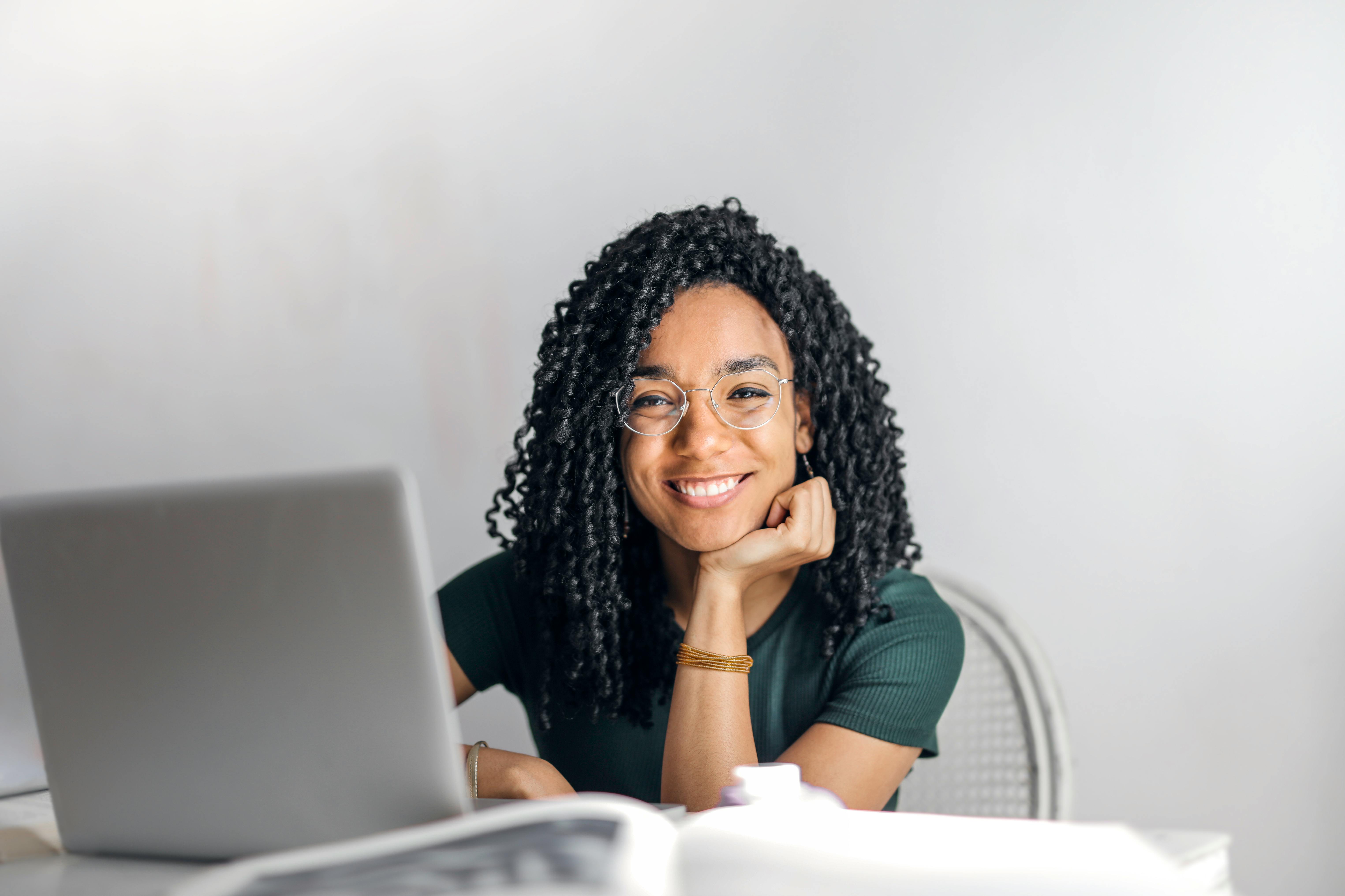 A woman with a laptop looking at the camera. 